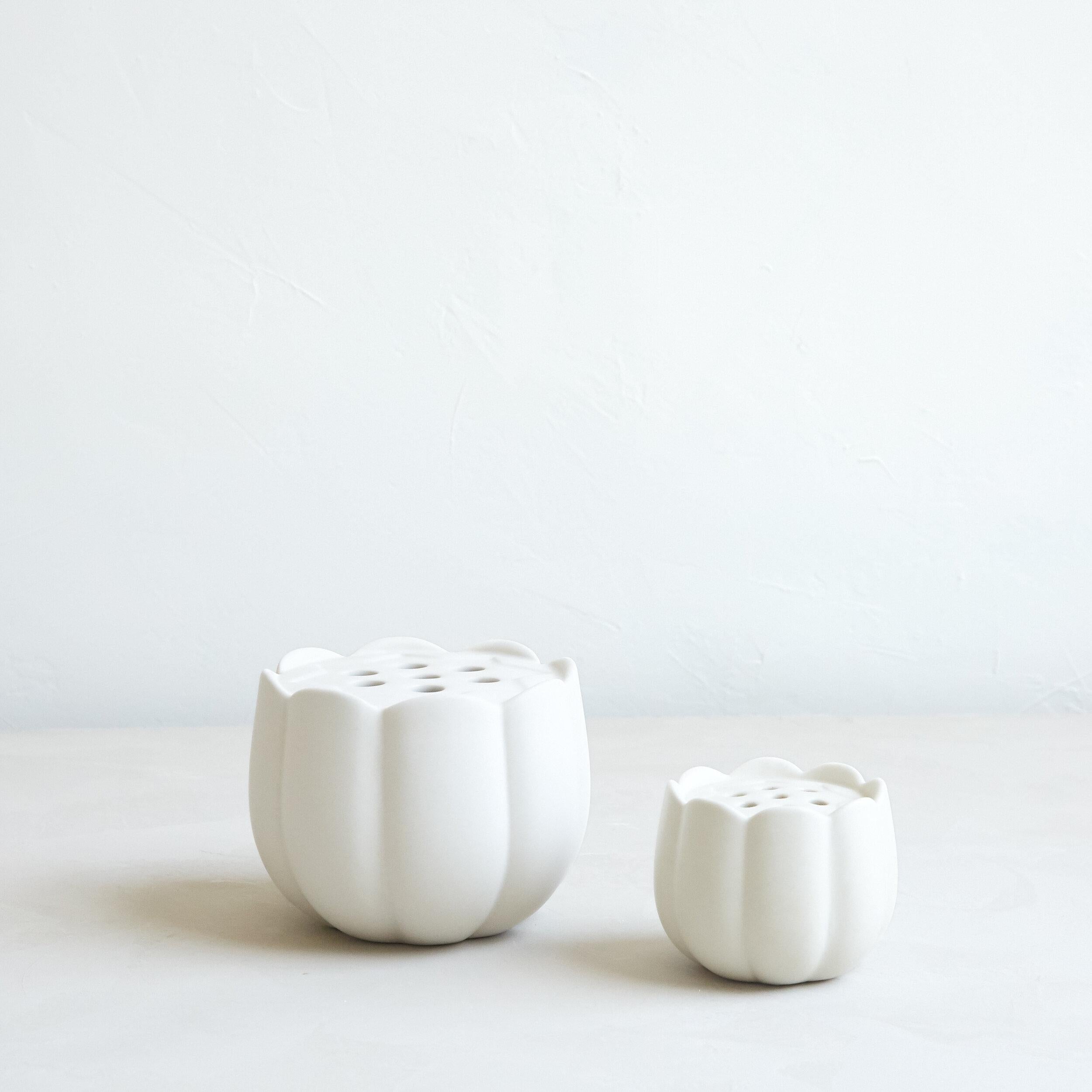 Two white ceramic vases on a light gray background