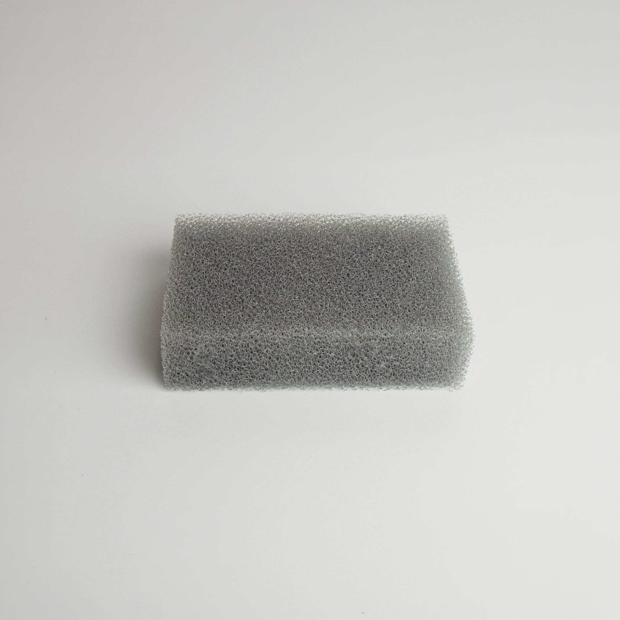 Gray Sunsun sponge expanded to its full size on a light gray background