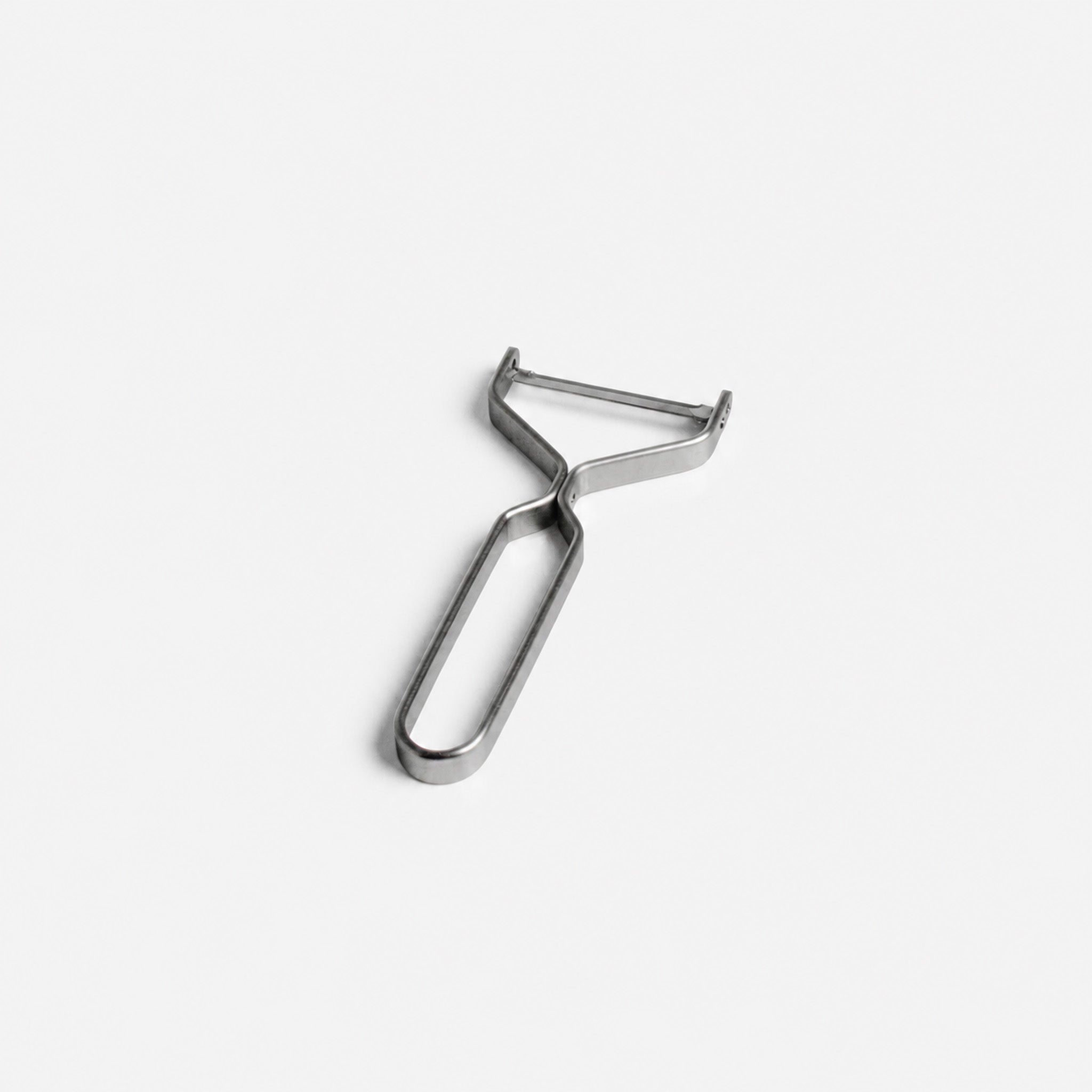 Yoshita stainless steel peeler on a light gray background