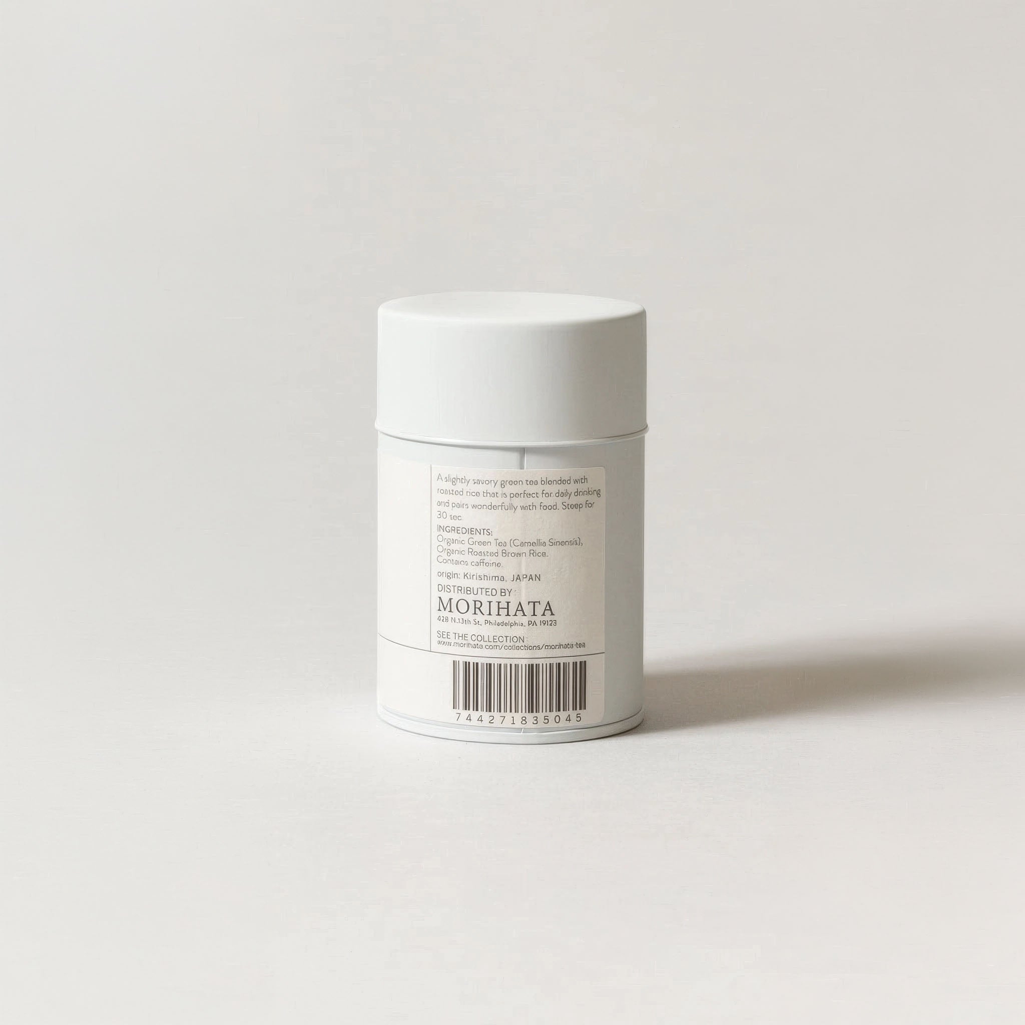 White cylindrical container with a label on a light gray background