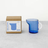 Blue mini pitcher with packaging on a light gray background