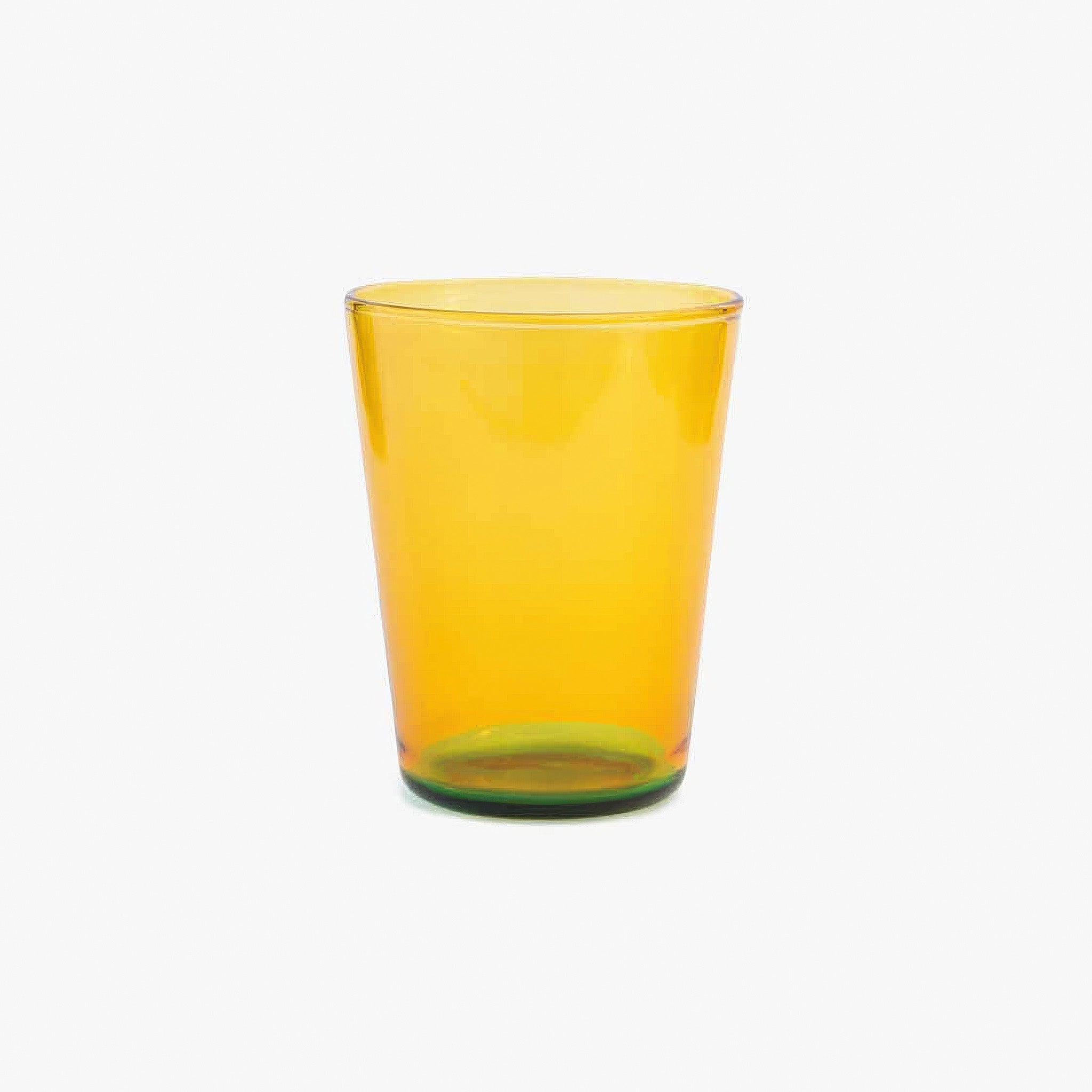 Two tone yellow glass tumbler on a white background
