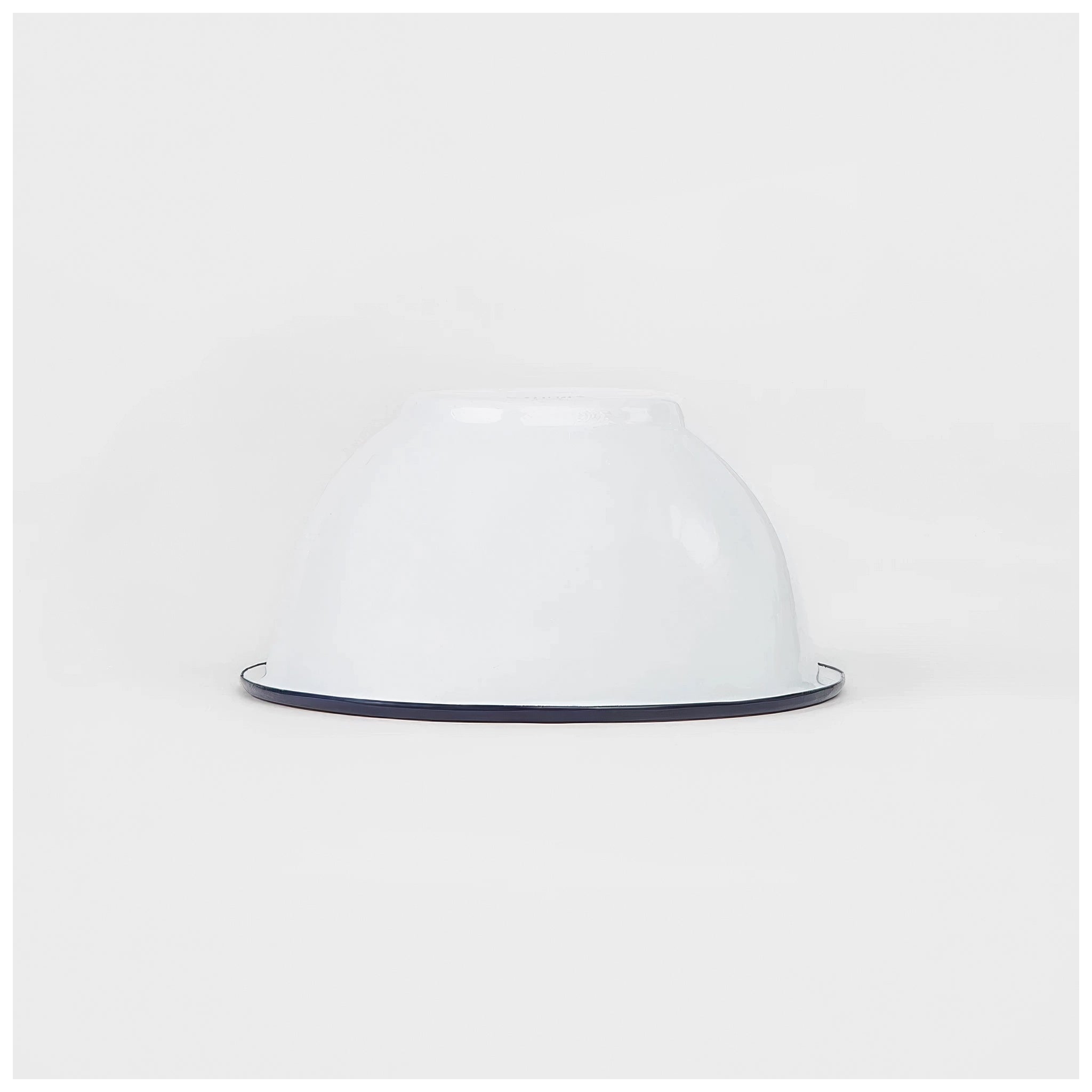 White enamelware bowl with a dark navy trim on a white background