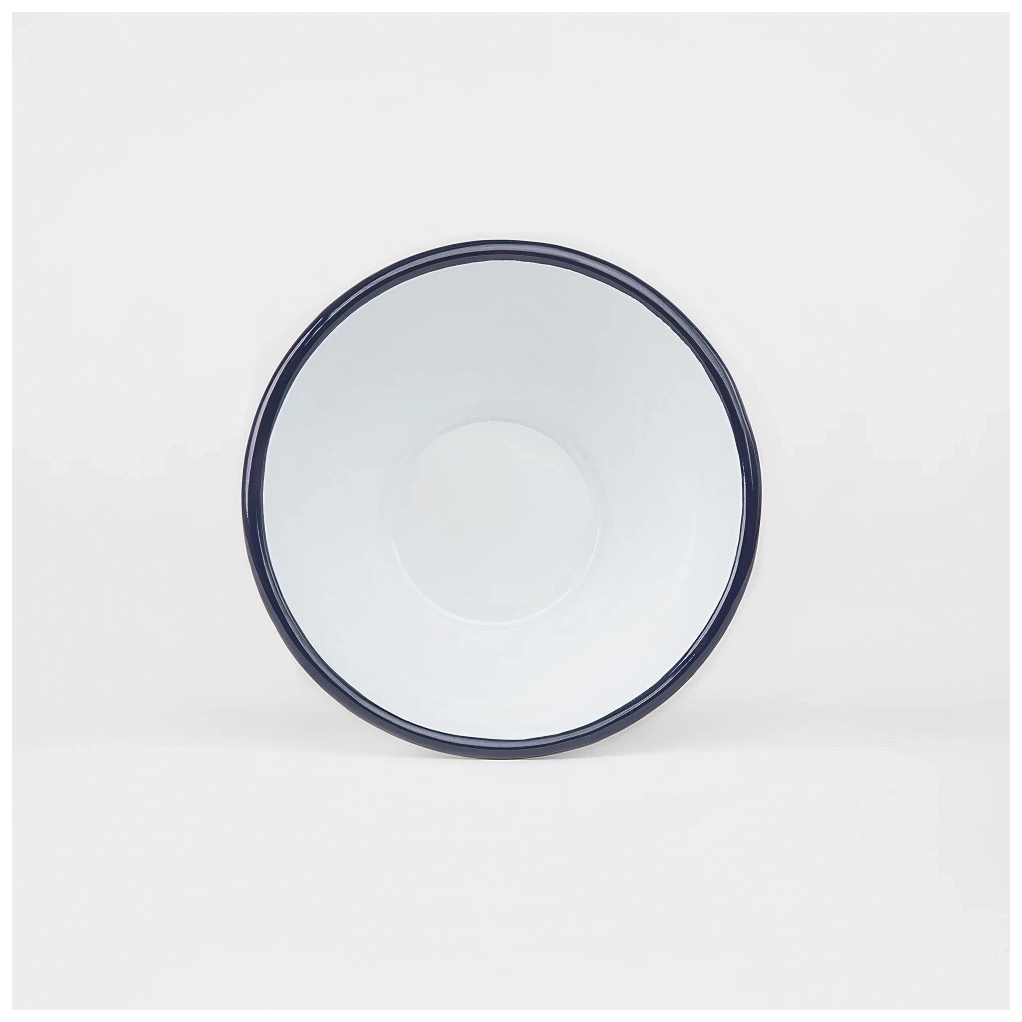 White enamelware bowl with a dark navy trim on a white background