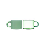 Two green mugs, one ceramic and one glass, on a white background