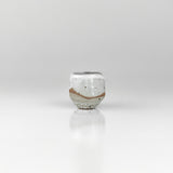 Small handcrafted ceramic sake cup with white glaze and exposed clay band, made by The Lazy Potters.