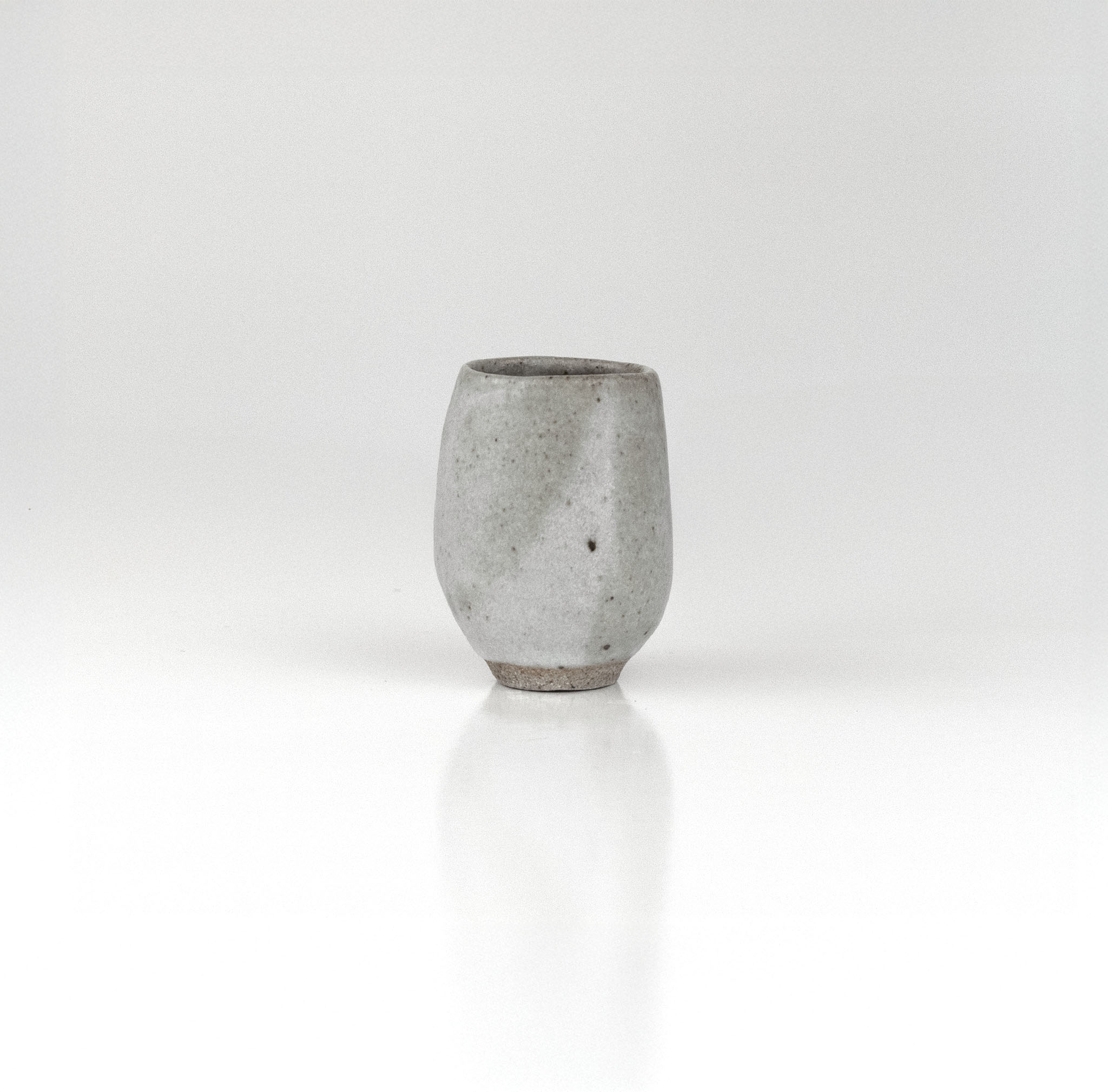 Tall slender handmade ceramic sake cup in soft grey glaze with smooth matte finish by The Lazy Potters.
