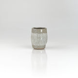 Hand-thrown ceramic sake cup with vertical white brush lines over grey glaze, by The Lazy Potters.