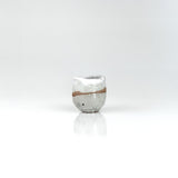 Compact handmade ceramic sake cup with soft white glaze and warm exposed clay horizon line, by The Lazy Potters.