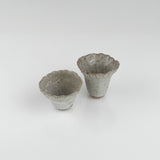 One-of-a-kind ceramic sake set featuring a rippled pourer and two textured cups in white speckled glaze by The Lazy Potters.