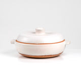 Limited edition off-white ceramic ttukbaegi  with terrapcotta colored rim on a white background