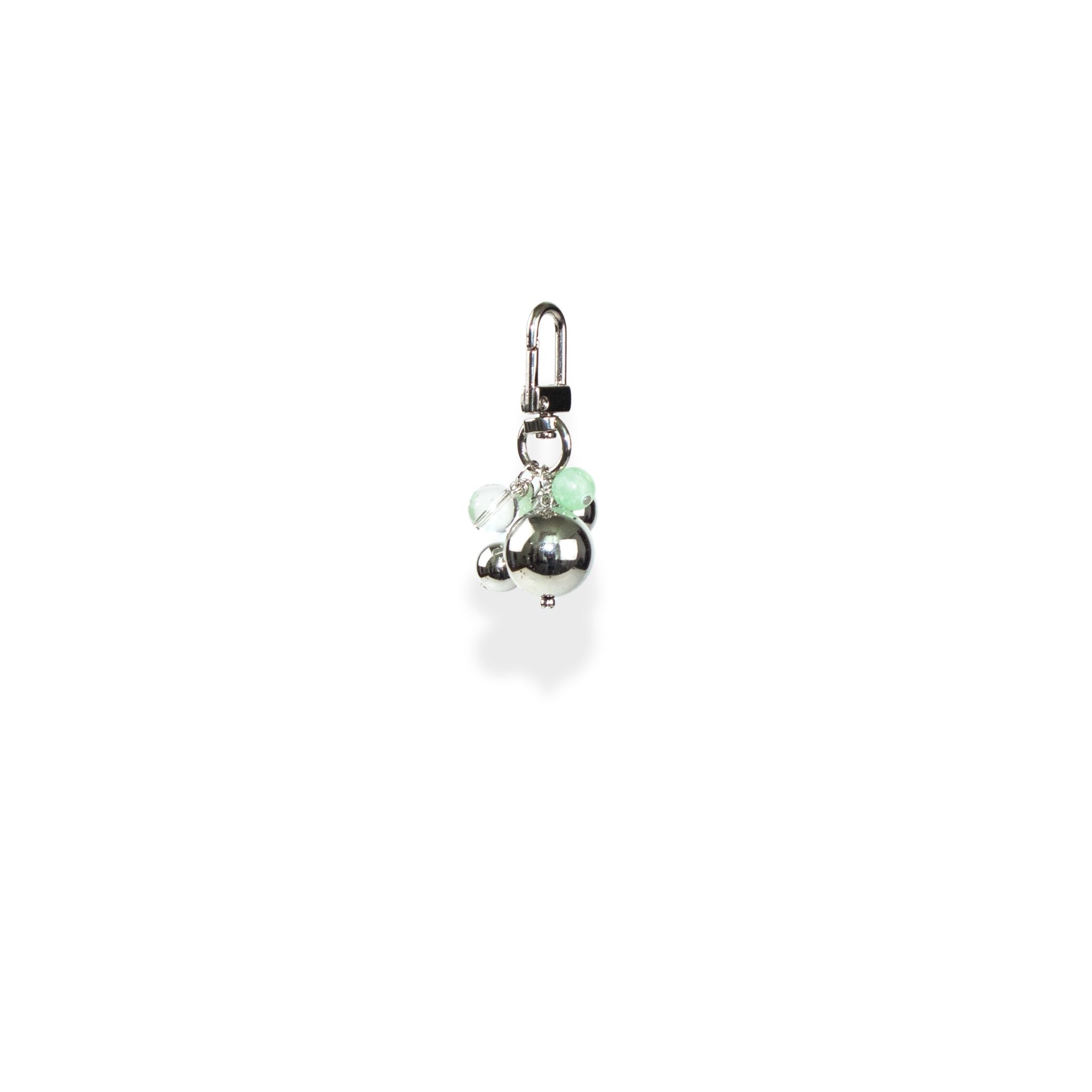 Silver charm with a green bead and a clear bead on a white background