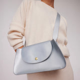  model holding wearing Minor History's The Horizon Crossbody bag sterling over shoulder