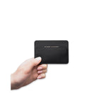 Image of a hand model holding Minor History metro card case black