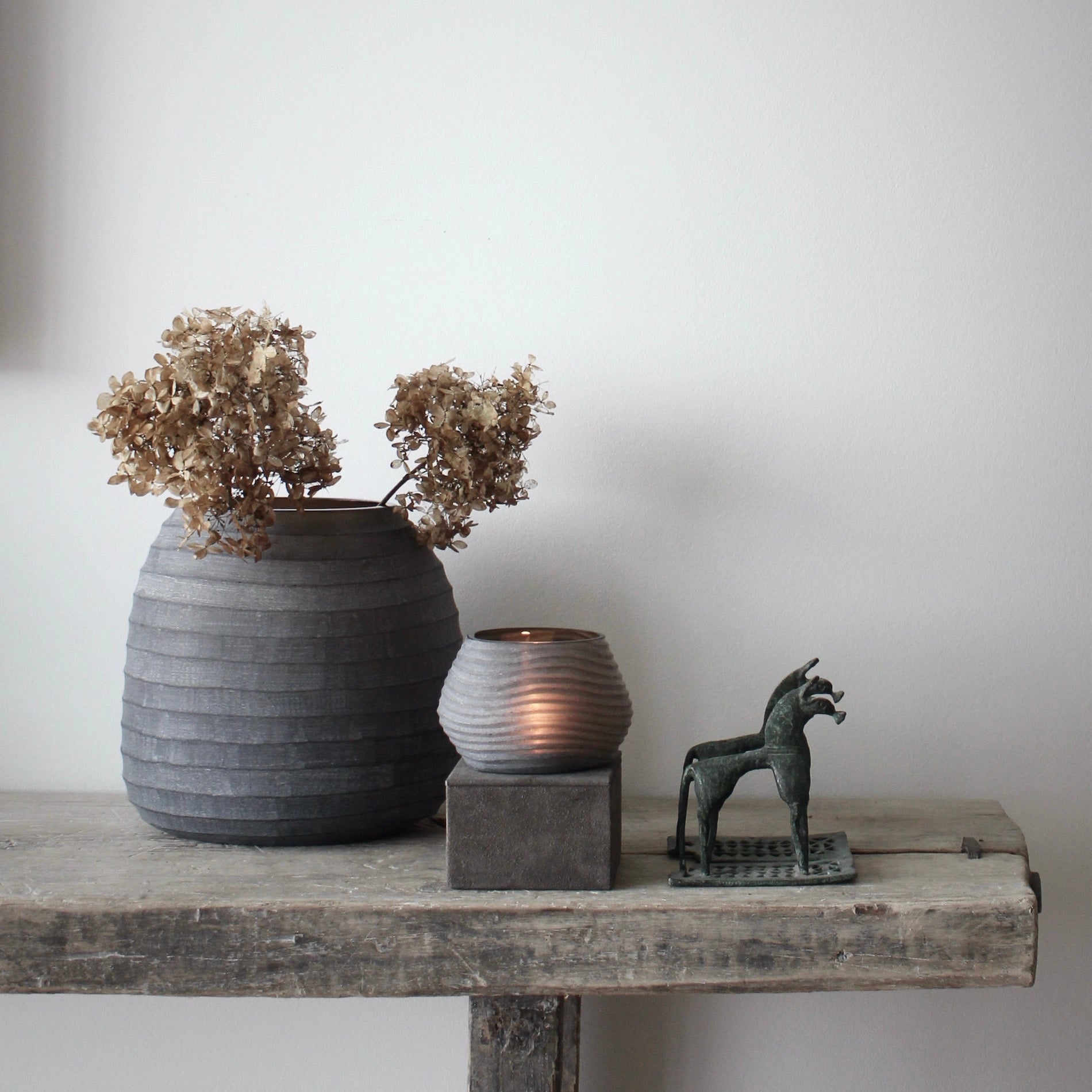 image of nordstjerne organic candle holder smoke color on bench with other products