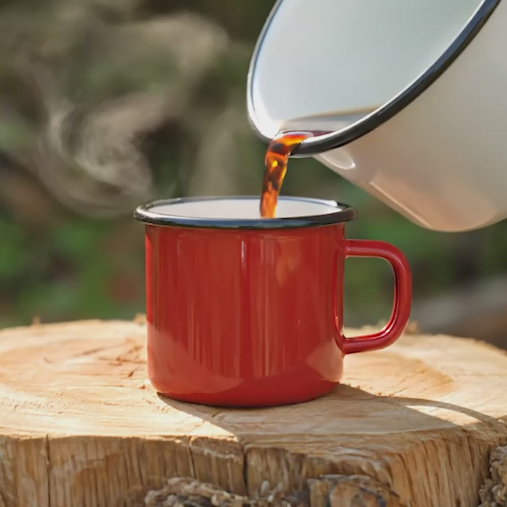 Video demonstrating hot steamy coffee being poured into enamel cups in the great outdoors 