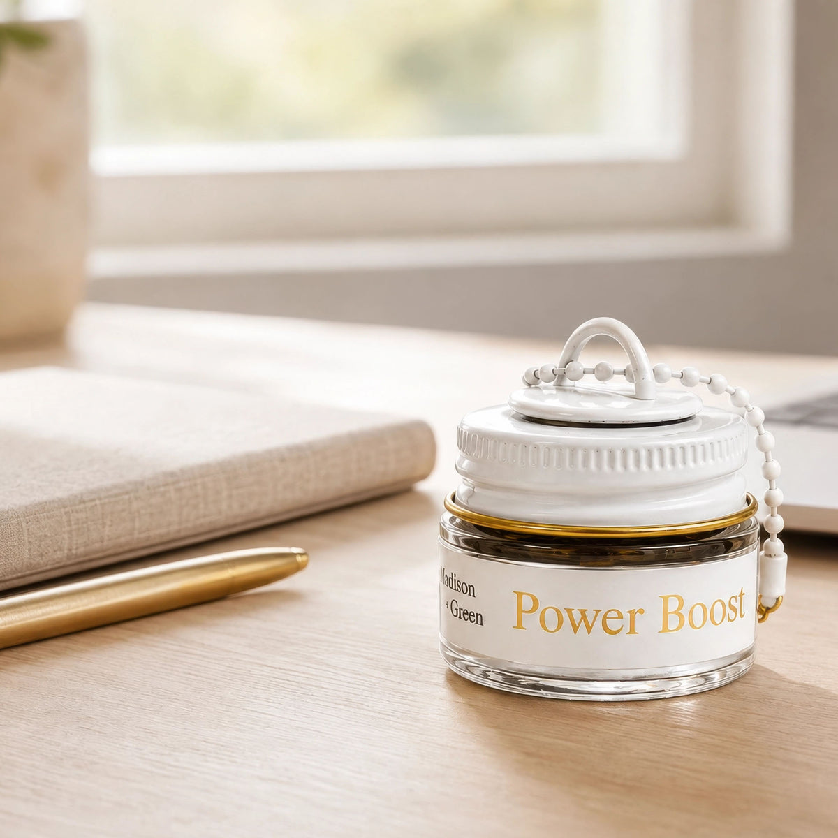 A jar of the 'Power Boost' inhaler sits on a wooden desk near a window, with a notebook, pen, and blurred background objects around it.