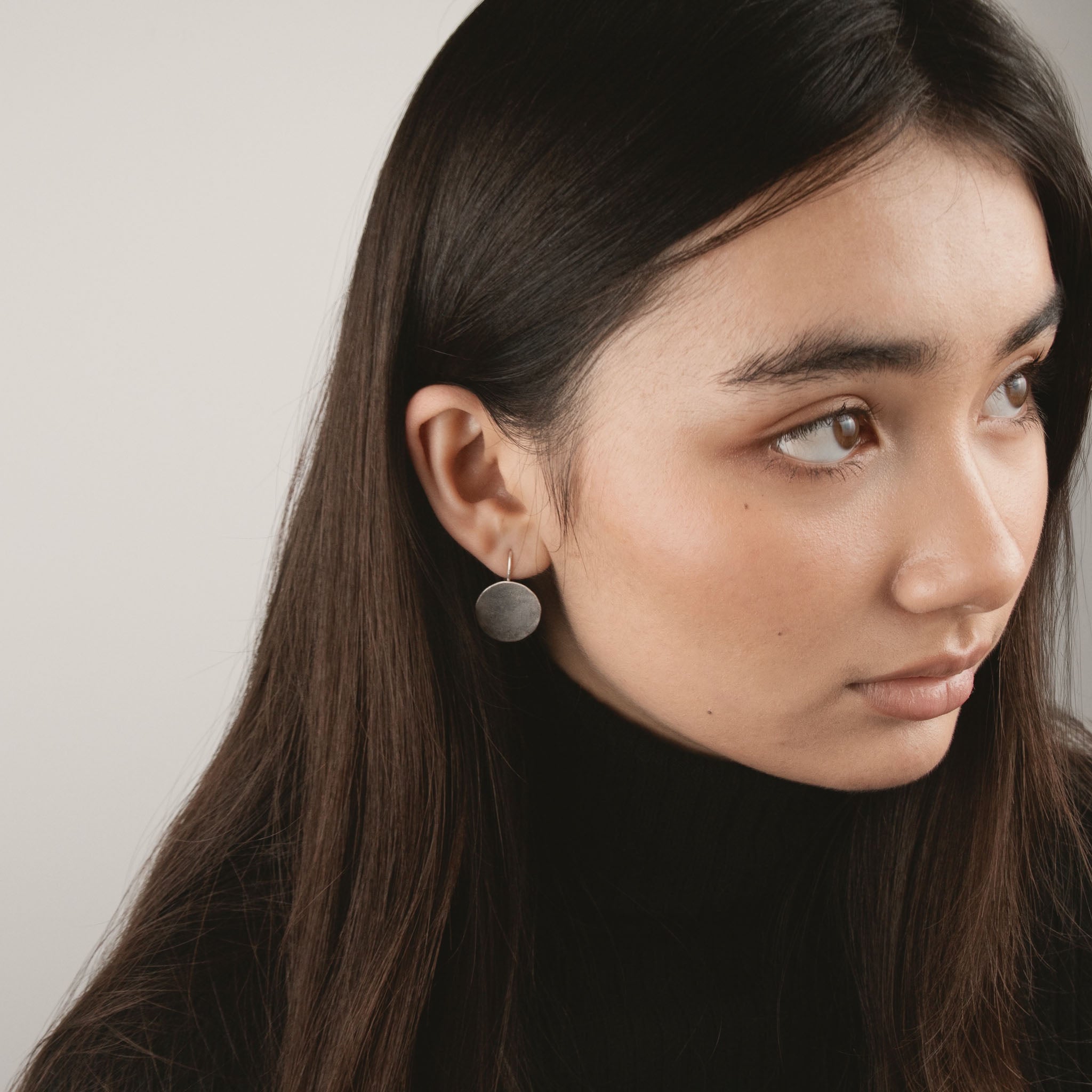 A model wearing the silver handcut coin earring 