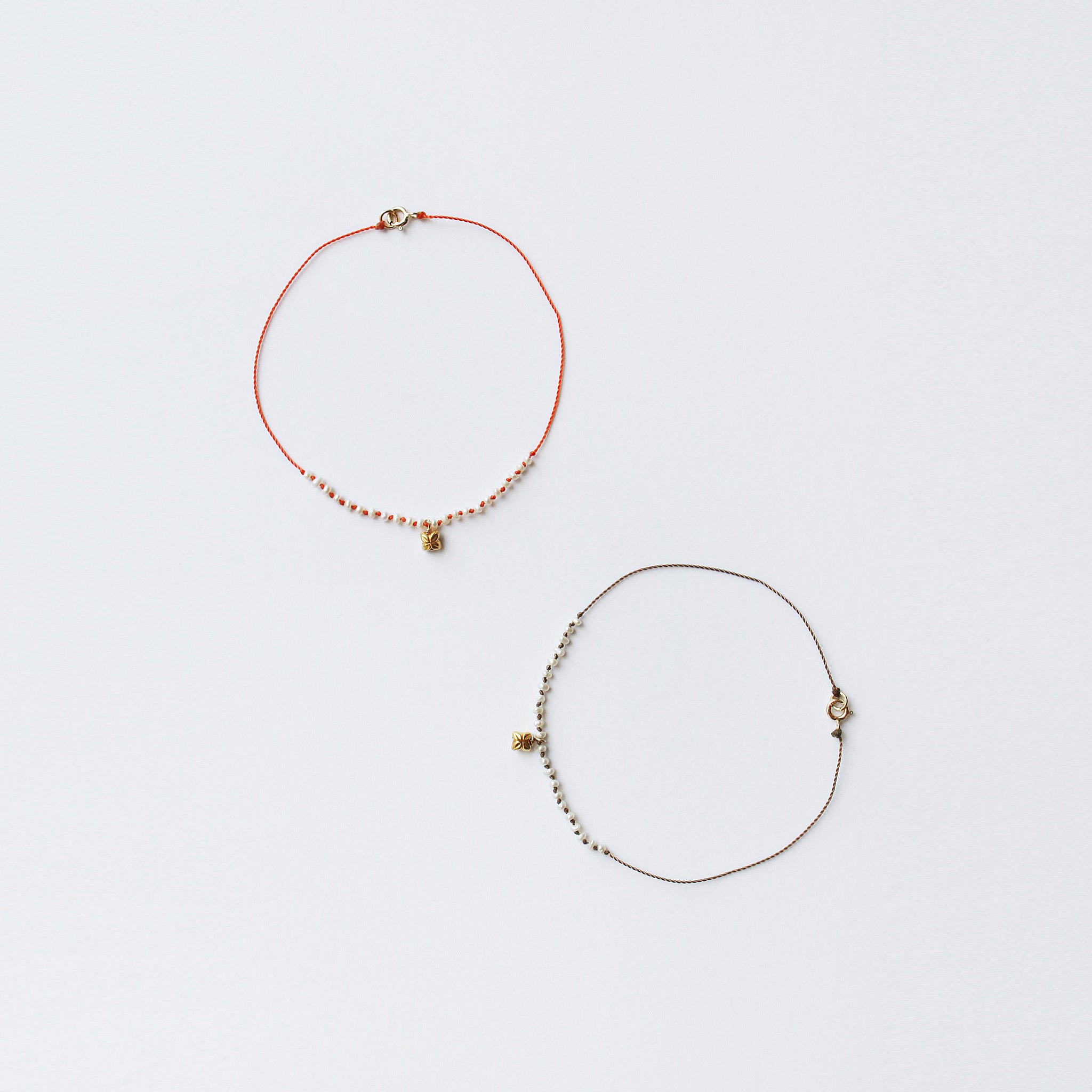 image of two see real flowers bracelets blossom charm lying next to each other latched in circular form