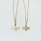 close up image of two see real flowers necklace next to each other with dragonfly design