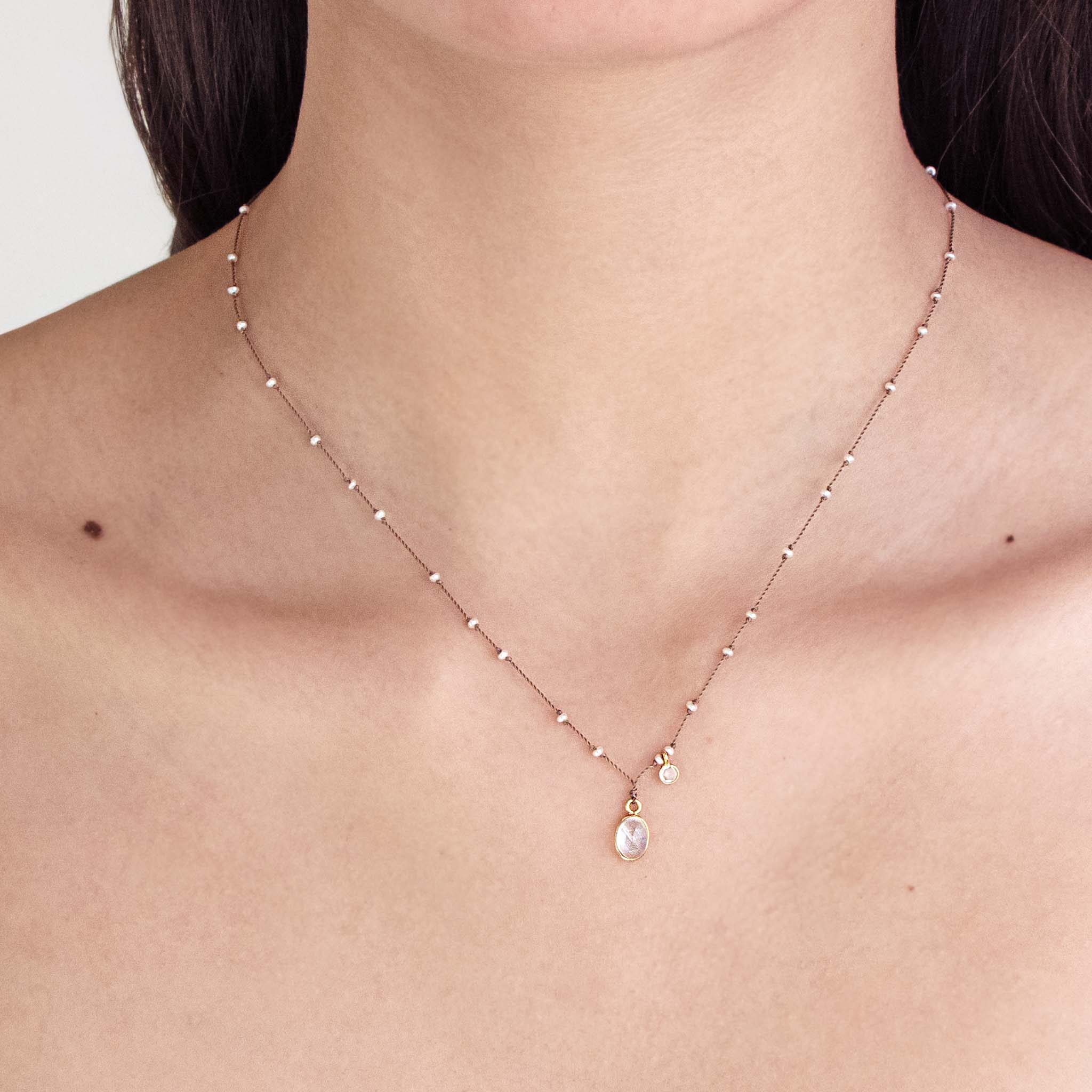 See Real Flowers You and Me necklace on a person's neck against a neutral background