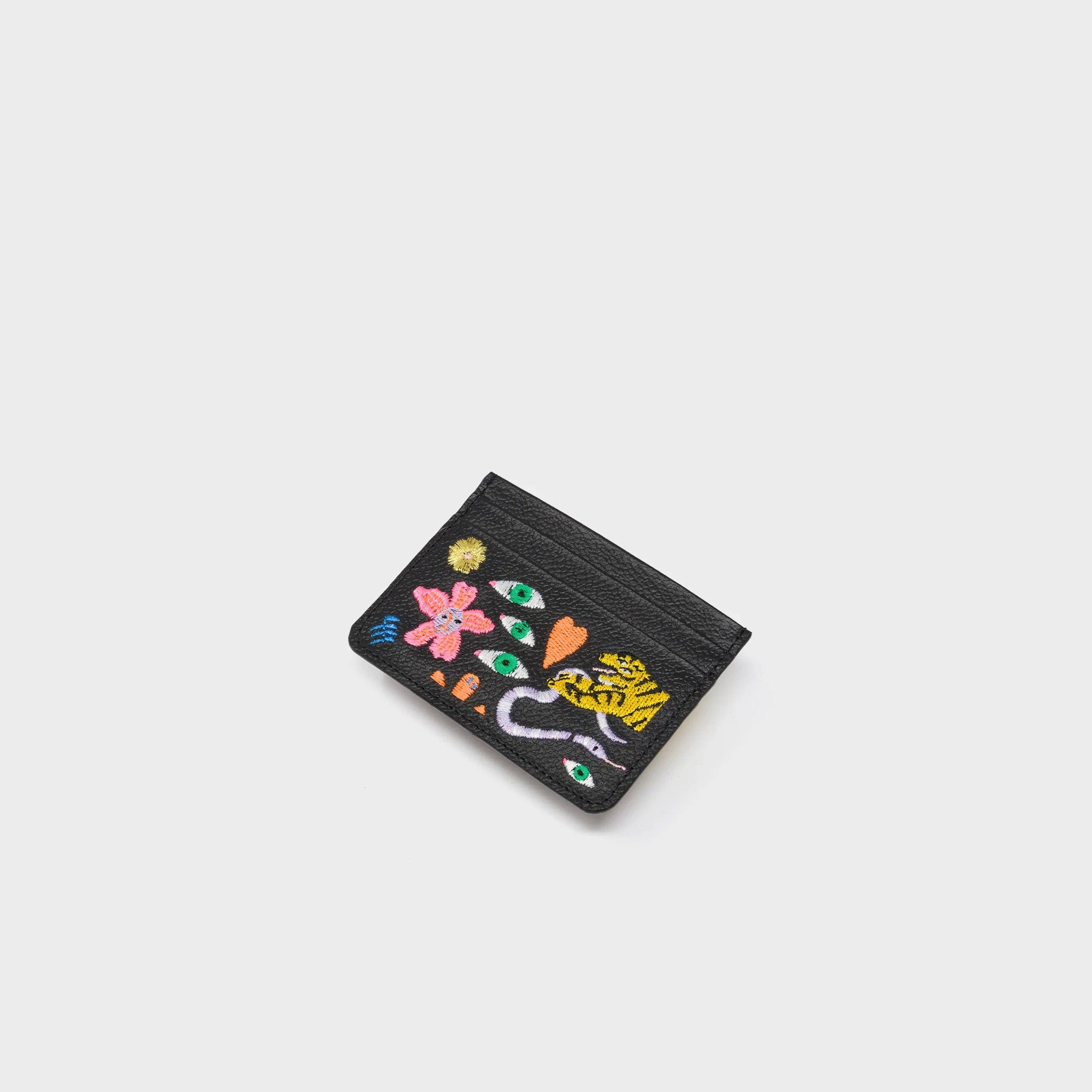 Black cardholder with colorful floral and animal designs on a white background