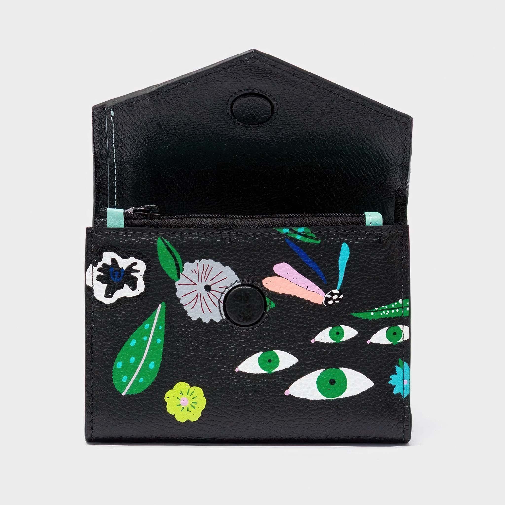 Black wallet with colorful floral and eye pattern on a white background opened.