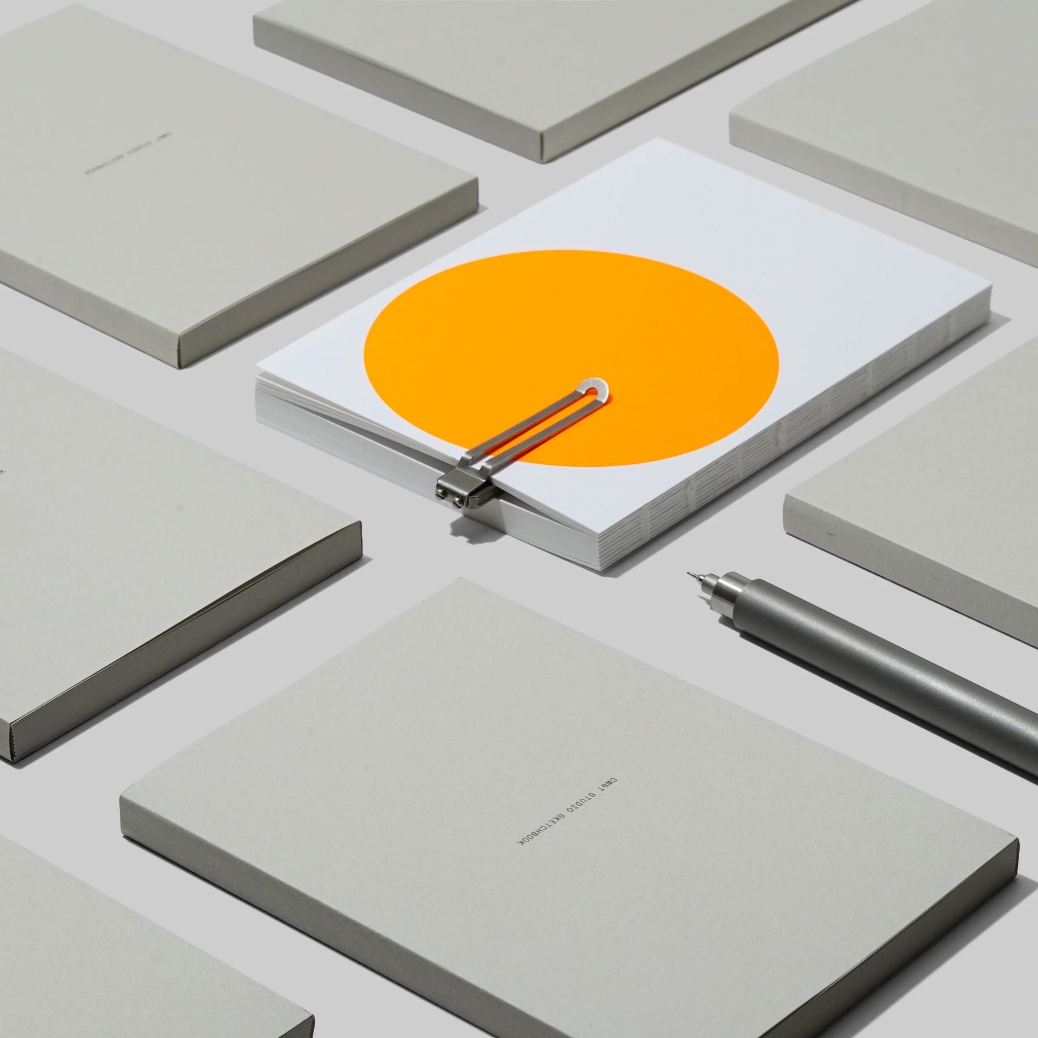 Aesthetic image of a collection of the studio sketchbooks laid out on a white background