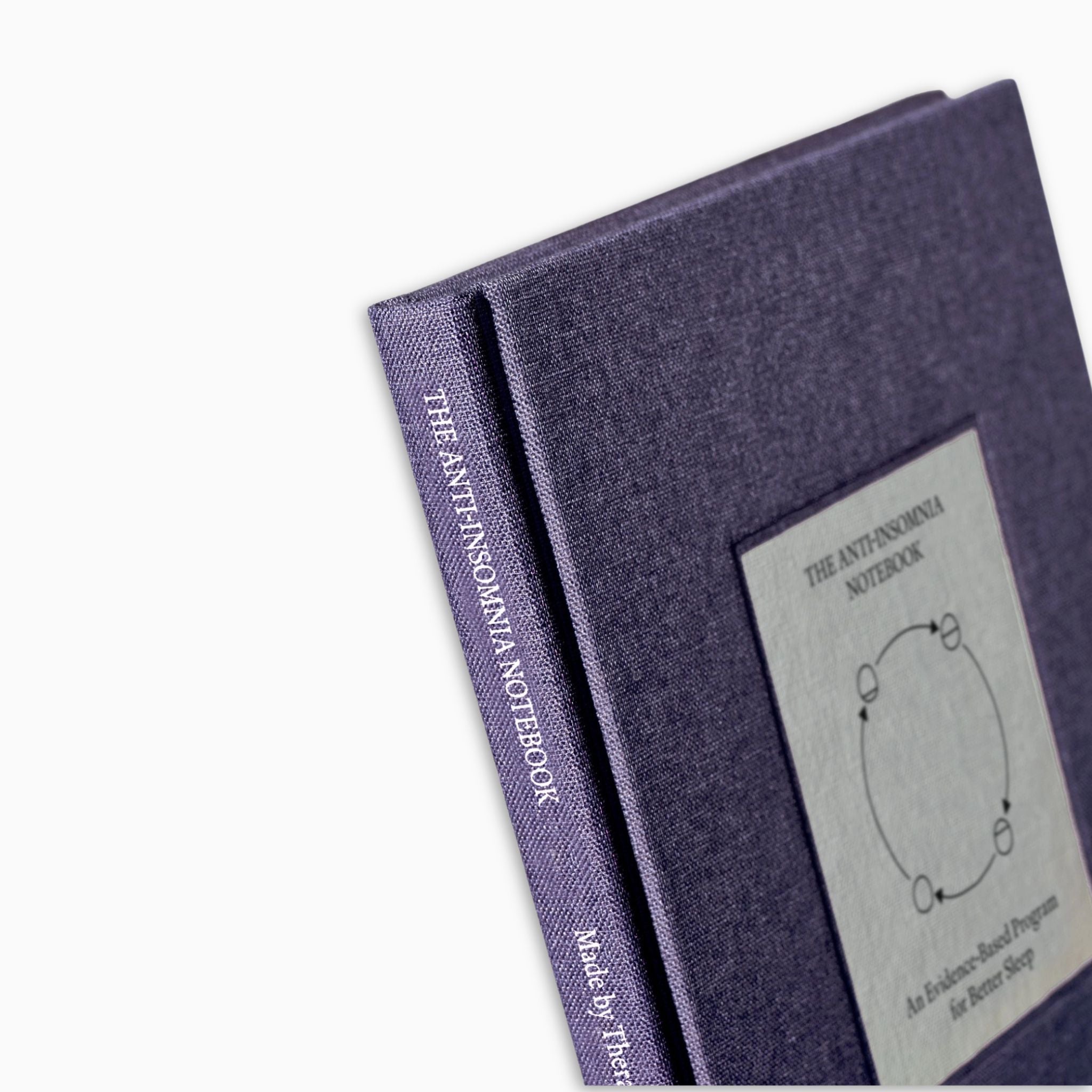 Close-up of The Anti-Insomnia Notebooks by Therapy Notebooks, featuring a linen hardcover with a minimalist stitched patch and embossed spine text.