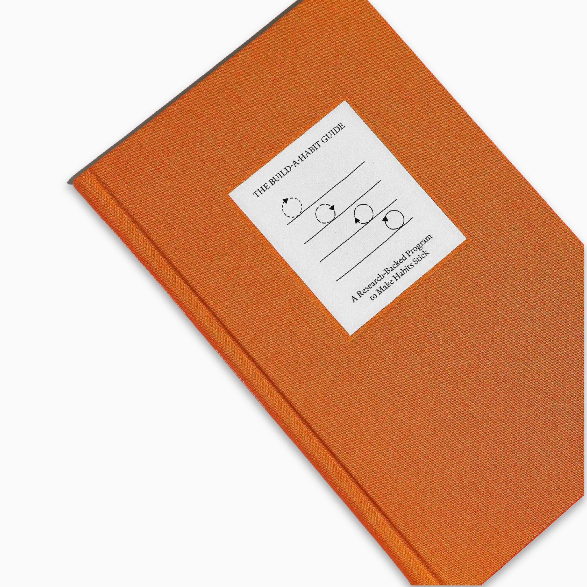 Top view of The Build A Habit Guide by Therapy Notebooks, featuring a linen hardcover with a minimalist stitched patch and embossed spine text.