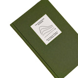 Top view of The After Trauma Notebook by Therapy Notebooks, featuring a linen hardcover with a minimalist stitched patch and embossed spine text.