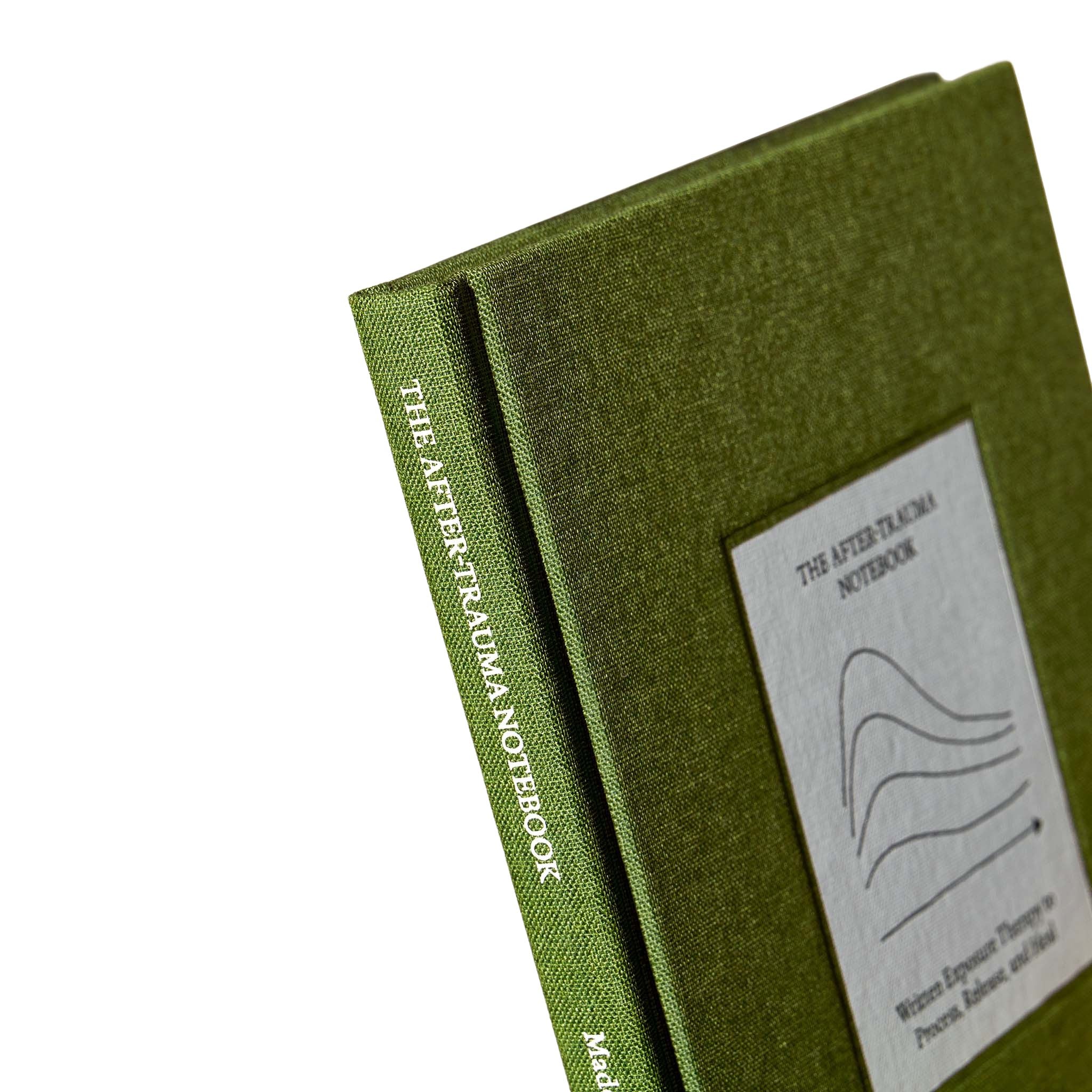 Close-up of The After Trauma Notebook by Therapy Notebooks, featuring a linen hardcover with a minimalist stitched patch and embossed spine text.