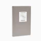 Full angled view of The Therapy Journal by Therapy Notebooks, featuring a linen hardcover with a minimalist stitched patch.