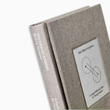 Close-up of The Therapy Journal by Therapy Notebooks, featuring a linen hardcover with a minimalist stitched patch and embossed spine text.