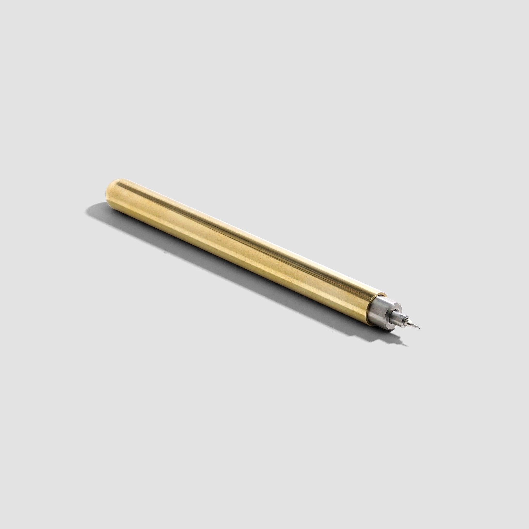 A slim metallic gold pen with a silver tip, shown diagonally on a light gray background with a soft shadow.