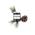 image of a jar of terralite scented candles nordic pine scent next to pine cones