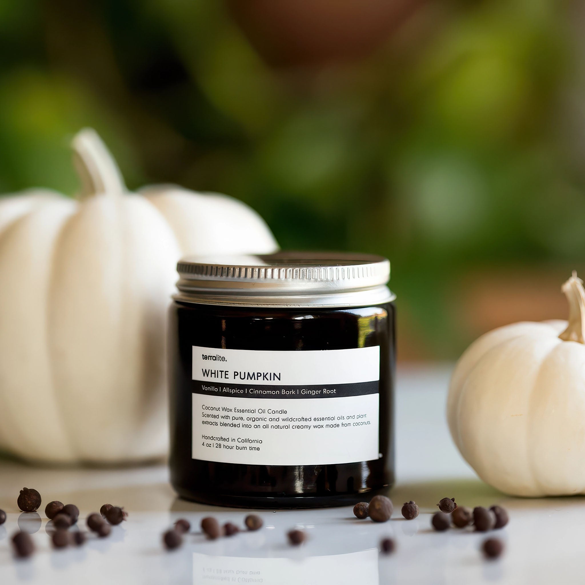 image of a jar of terralite scented candles white pumpkin scent with white pumpkins in the background