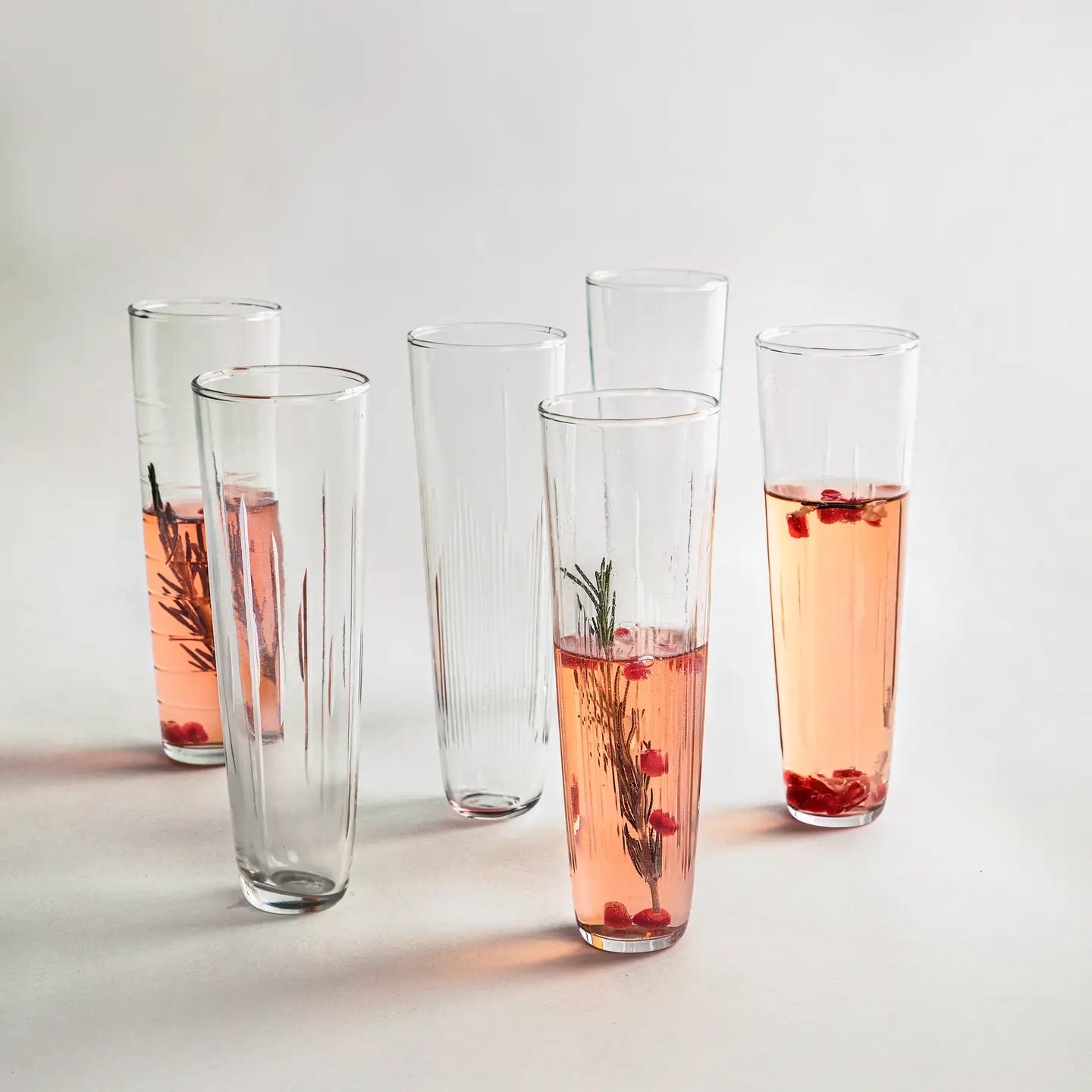 image of six the collective flutes  half filled with pink liquid