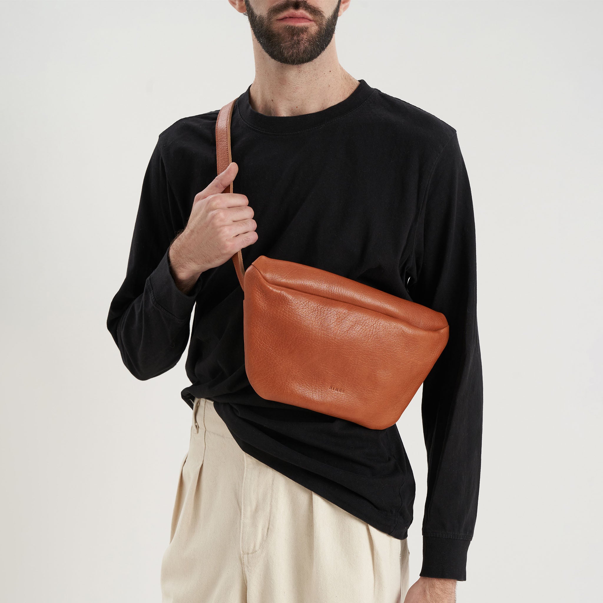image of modelswearing nimes conesa fanny packs tobacco color over chest