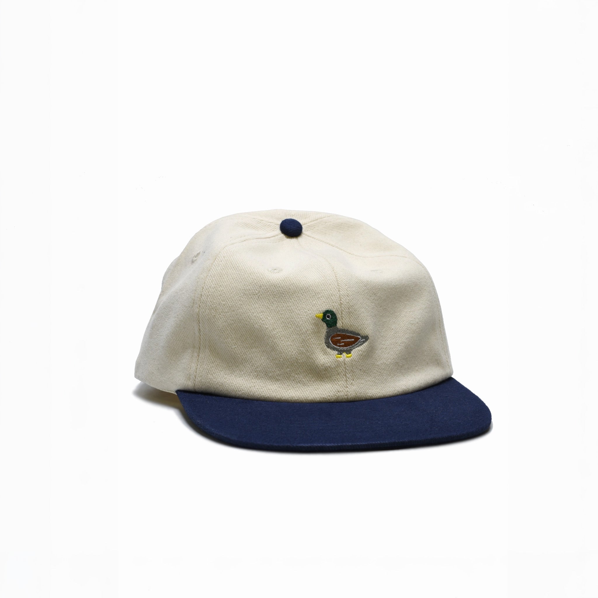 White and navy cap with an embroidered duck on a white background