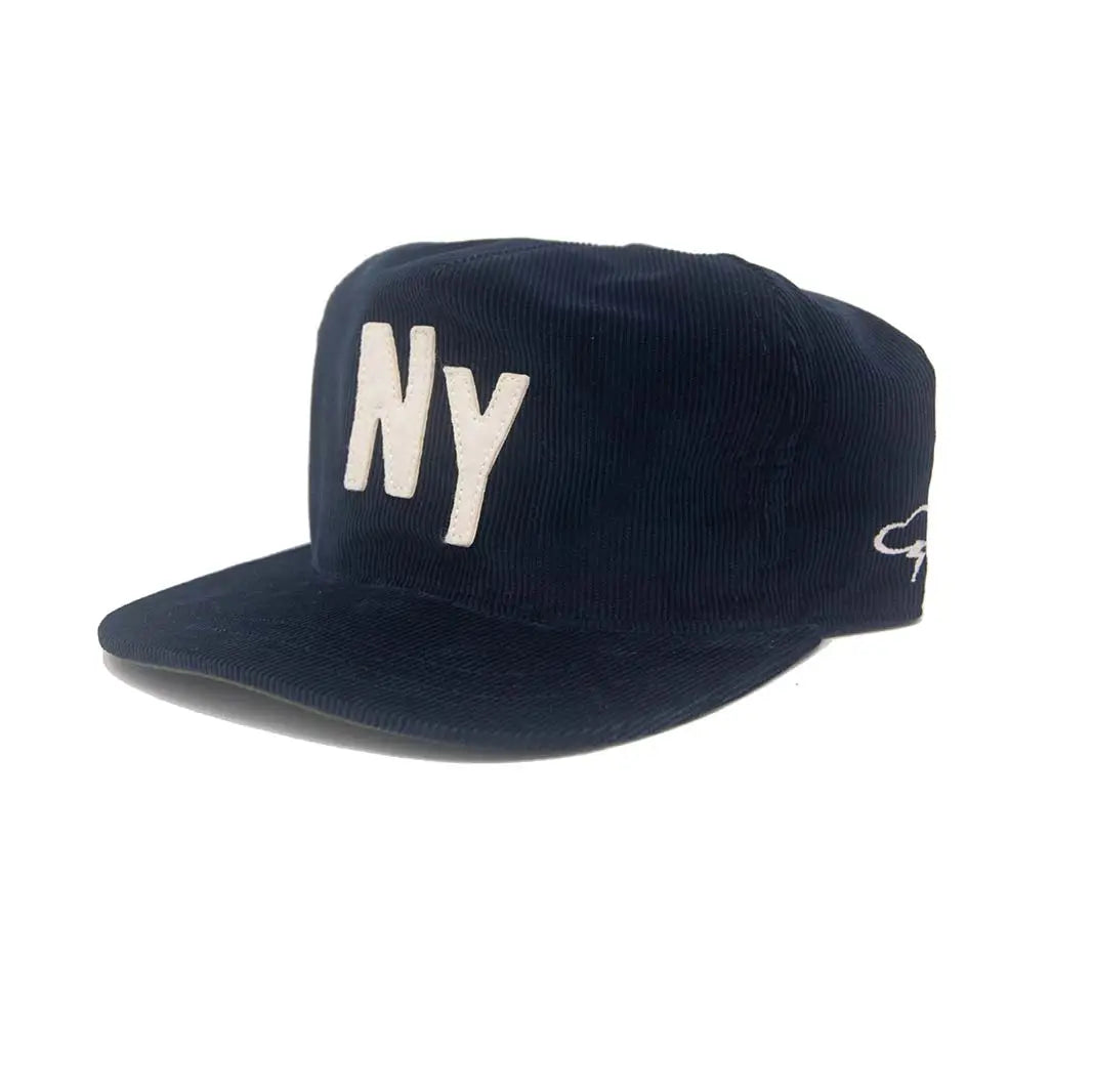 A dark navy blue corduroy flat-brim cap featuring a prominent white embroidered 'NY' logo on the front and a small white embroidered logo on the side, set against a plain white background.