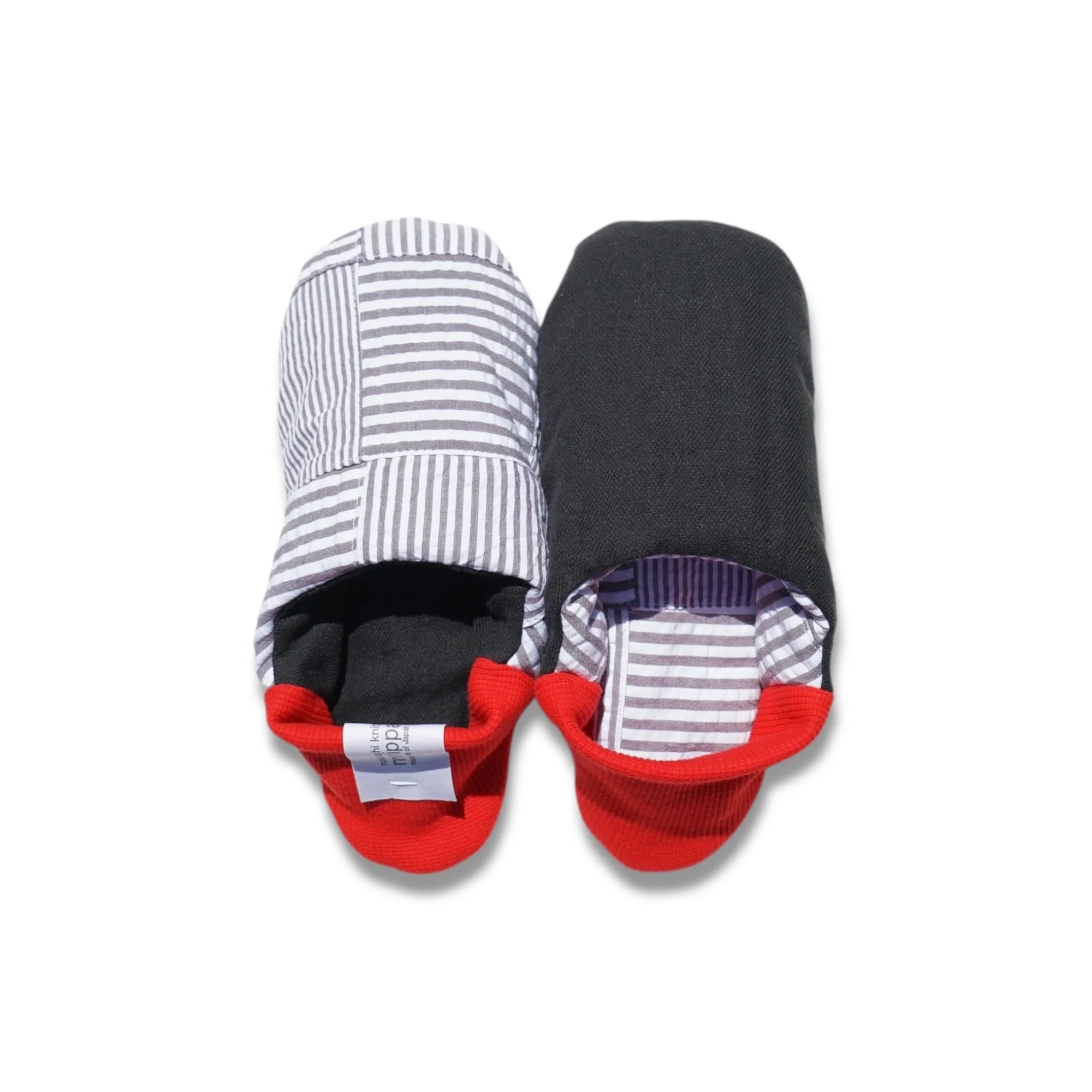 Pair of grey striped slippers with red heels on a white background